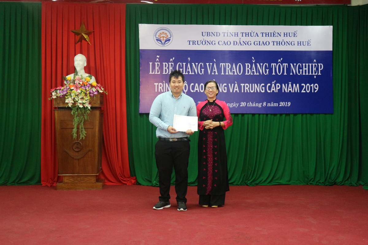 Cô Lê Thị Loan - Trưởng phòng Tài chính - Kế toán trao học bổng cho tân sinh viên khóa CD18